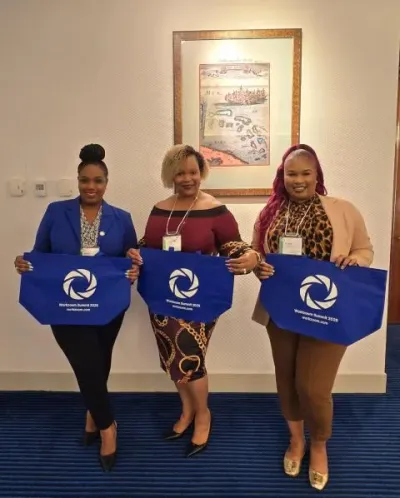 Three attendees holding Workzoom Summit 2025 tote bags